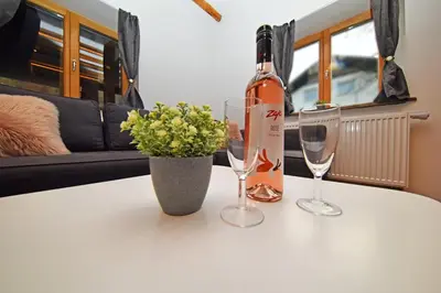 a bottle of wine and two glasses on a table at Hiša stare mame in Kamnik