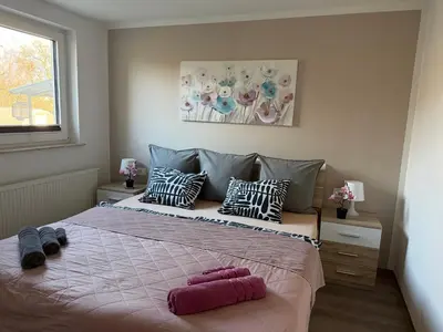 a bedroom with a large bed with pink pillows at Apartments Mici in Bled