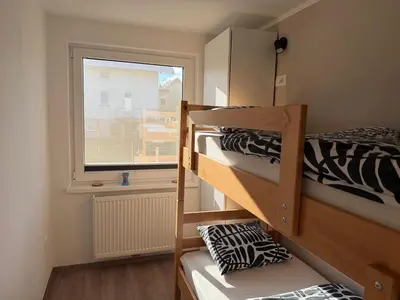 two bunk beds in a room with a window at Apartments Mici in Bled