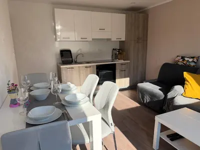 a kitchen and living room with a table and chairs at Apartments Mici in Bled