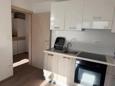 a kitchen with white cabinets and a sink and a stove at Apartments Mici in Bled