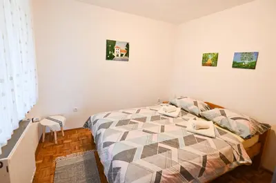a bedroom with a bed and some pictures on the wall at Počitniška hiša Parkfield Dragovan in Metlika