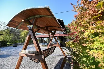 a wooden chair sitting in front of a building at Počitniška hiša Parkfield Dragovan in Metlika