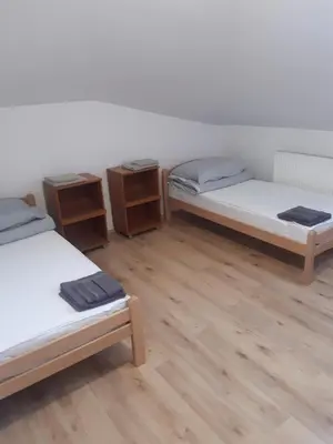 three beds in a room with wooden floors at APP PARCELA CELJE in Celje