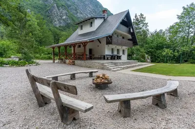 a building with benches in front of a building with a fire at Holiday House Destina - Lake Bohinj in Bohinj