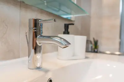 a bathroom sink with a chrome faucet on a counter at Holiday House Destina - Lake Bohinj in Bohinj