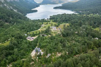 an aerial view of a house on a hill next to a lake at Holiday House Destina - Lake Bohinj in Bohinj