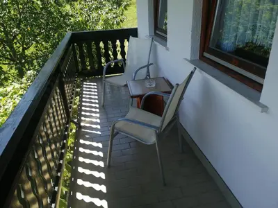 two chairs and a table on a balcony at Apartma Gorca Plevnik in Buče