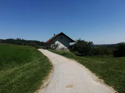 a dirt road leading to a house on a hill at Apartma Gorca Plevnik in Buče