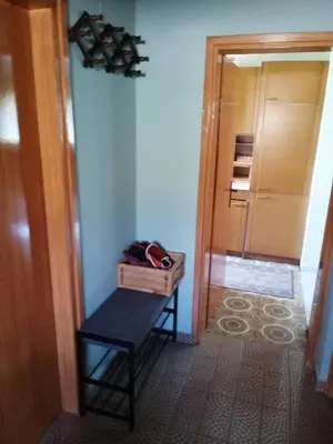 a hallway with a bench in a room with a door at Apartma Gorca Plevnik in Buče