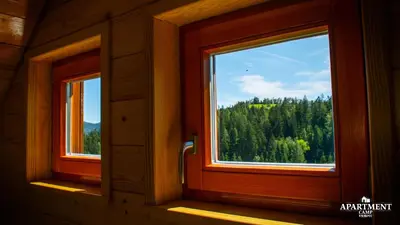two windows in a room with a view of trees at Wooden Chalet - Homestead Vrhovc in Železniki