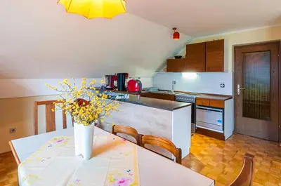 a kitchen with a table with a vase of flowers on it at Spacious apartment in Bled