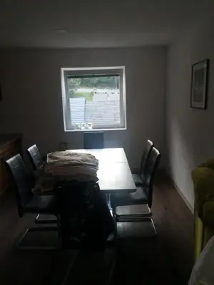 a dining room table with chairs and a window at Apartma Alja Podkoren in Kranjska Gora