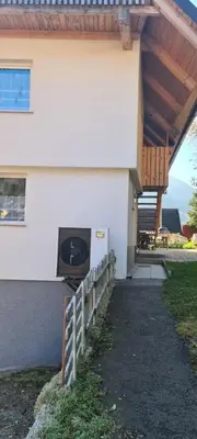 a house with a porch with a fence in front of it at Apartma Alja Podkoren in Kranjska Gora