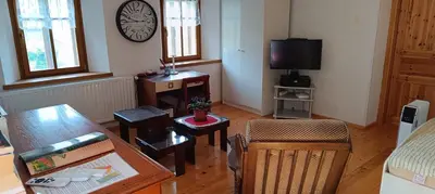 a living room with a table and chairs and a television at Apartment Perunika in Cerkno