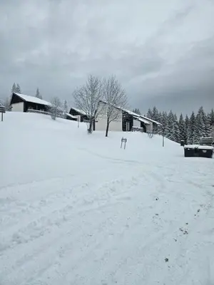 a field covered in snow with houses and trees at Apartma Rogla Gaber 63 in Zreče
