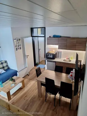 a living room with a table and a kitchen at Apartma Rogla Gaber 63 in Zreče