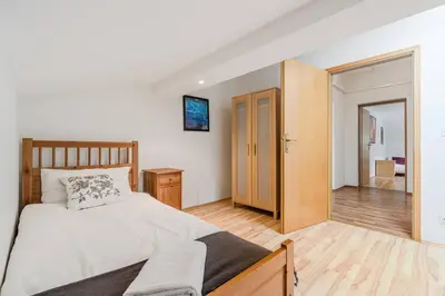 a bedroom with a bed and a wooden floor at Vila Labod, unique villa at the lake in Most na Soči