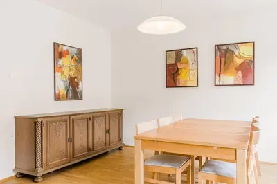 a dining room with a table and two paintings on the wall at Vila Labod, unique villa at the lake in Most na Soči