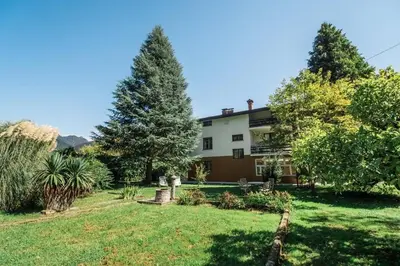 a house in a yard with trees and grass at Vila Labod, unique villa at the lake in Most na Soči