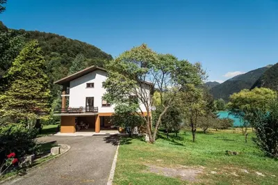 a house with a view of a lake and mountains at Vila Labod, unique villa at the lake in Most na Soči