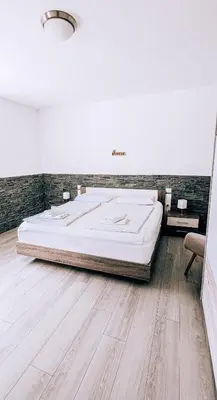 a large bed in a room with a wooden floor at LTE Apartments in Maribor