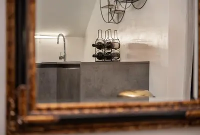 a mirror reflection of a kitchen counter with a sink at LTE Apartments in Maribor