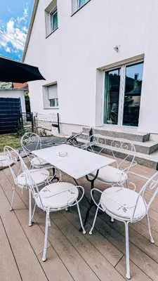 a picnic table and four chairs on a deck at LTE Apartments in Maribor