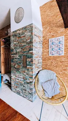 a room with a chair and a brick wall at LTE Apartments in Maribor