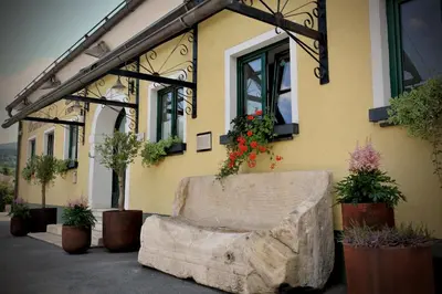a building with a stone bench in front of it at Gostilna in Prenočišča Brančurnik in Prevalje