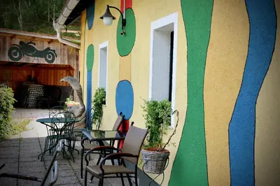 a building with tables and chairs in a patio at Gostilna in Prenočišča Brančurnik in Prevalje