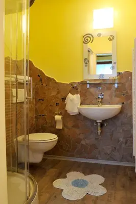 a bathroom with a sink and a toilet and a mirror at Gostilna in Prenočišča Brančurnik in Prevalje