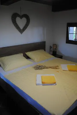 a bedroom with two beds with a heart on the wall at Vorgova klet in Bogojina