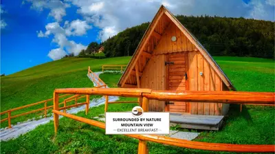 a small wooden building with a sign in front of it at Glamping Vrhovc in Železniki