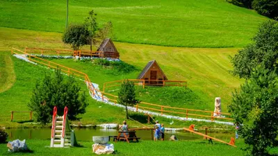 a group of people playing in a park with a playground at Glamping Vrhovc in Železniki