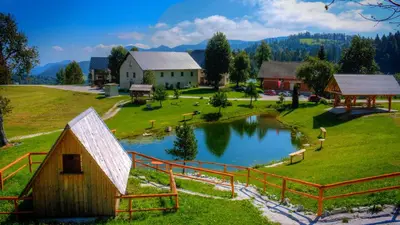 a model of a farm with a pond and a barn at Glamping Vrhovc in Železniki