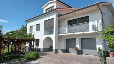 a white house with a balcony at Apartma Nona Roža in Zgornje Škofije