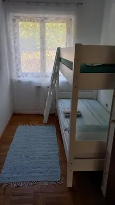 a bunk bed and a ladder in a room with a window at Apartma Nona Roža in Zgornje Škofije