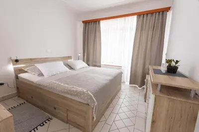 a bedroom with a large bed and a window at Apartmaji Natura KOLPA in Adlešiči