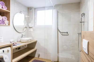a bathroom with a glass shower and a sink at Apartmaji Natura KOLPA in Adlešiči