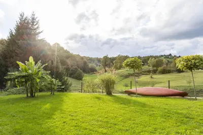 a red boat on the grass in a field at Apartmaji Natura KOLPA in Adlešiči