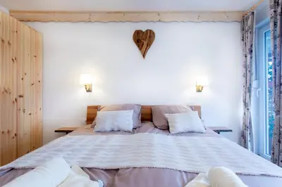 a bedroom with a large bed with two pillows at Honey apartments in Žirovnica