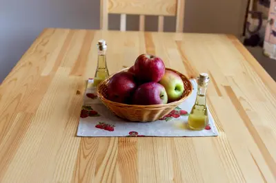 a basket of apples and two bottles of juice on a table at Honey apartments in Žirovnica
