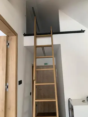 a ladder leading up to a loft bed in a room at 18Home apartments, Mojstrana in Mojstrana