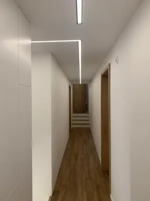 a hallway with white walls and wood floors at 18Home apartments, Mojstrana in Mojstrana