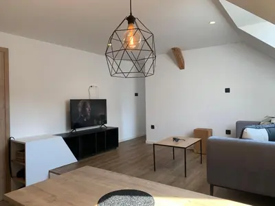 a living room with a couch and a tv at 18Home apartments, Mojstrana in Mojstrana