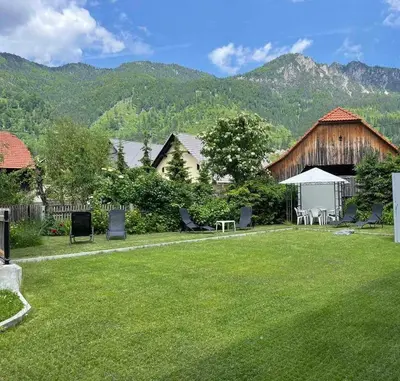 a yard with a barn and a table and chairs at 18Home apartments, Mojstrana in Mojstrana