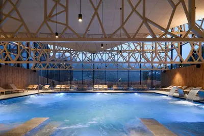 a large swimming pool with chairs in a building at Green Oasis Anica in Podčetrtek