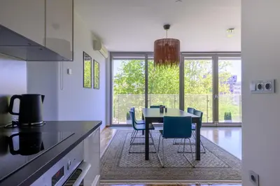 a kitchen with a table and chairs in a room at Sunrise Maribor apartment with private parking in Maribor
