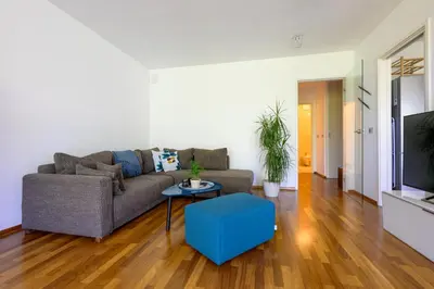 a living room with a couch and a table at Sunrise Maribor apartment with private parking in Maribor